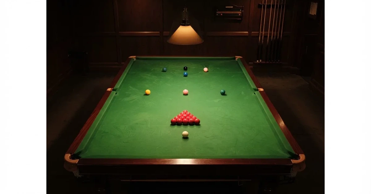Stół snookerowy z zielonym suknem widziany z góry, rozstawione kolorowe bile w pustym salonie gry.